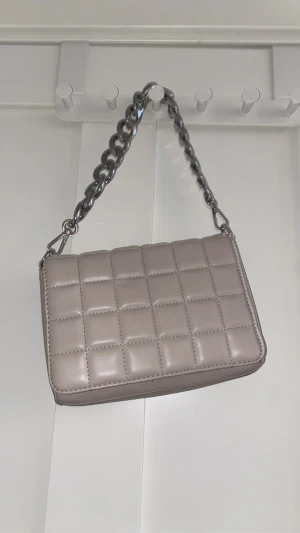 Beige väska - Det är kjedja men också så kan man ha vanligt band som är till