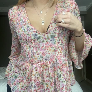 Blommig blus - Så söt o snygg blommig blus med den snyggaste v ringningen. Perfekt till ett par jeans eller en kjol