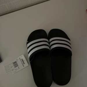 Tofflor - Oanvända adidastofflor i storlek 39