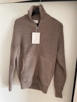 ZARA Orgins Zip träja - Säljer min zip tröja från ZARA från kollektionen ZARA Orgins då den inte kommer till någon användning tyvärr. Storlek S och färgen är brun. Designen är ribbad som ni ser på bilderna. Prislappen kvar, har inte använts sen köpet. Kontakta vid frågor!