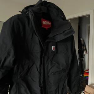 Parkas jacka  - En parkas jacka ifrån fjällräven! Köpt begagnat för flera år sedan och har sen dess legat i källaren! I bra skick! Rak i modellen och går strax över knäna på mig som är 165 cm!