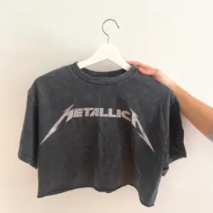 Croppad topp oklart märke, strl M. Mörkgrå med ljusare ”Metallica” text. Använd en gång. 50kr plus frakt.