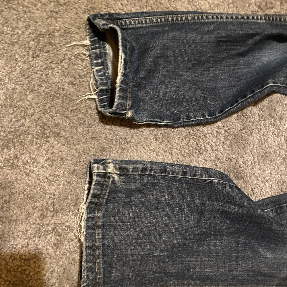 Lågmidjade jeans från wrangler i snygg blå tvätt. Köpta second hand men endast använda fåtal gånger av mig. Lite slitningar (bild 3) men inget märkbart 💓Midjetmåttet är ca 80cm. Jeans & Byxor.