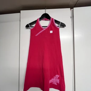 Äkta y2k-klänning med rosa detaljer - Superfin röd klänning från F.L.Y. med en rosa fjäril på🤩 Äkta y2k och knappt använd! Säljer pga det inte är min stil. Så skön i materialet o är jättestretchig så den passar många! 