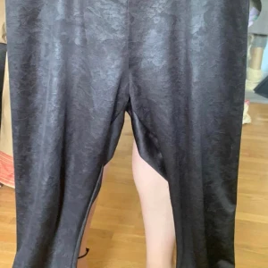 Byxor  - Svarta byxor med märken i tyget 