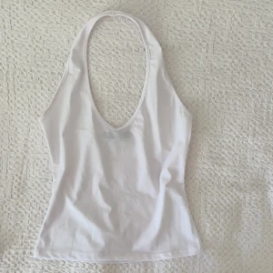 Vit halterneck  - Säljer denna vita halterneck som är figursydd och formar sig jättefint på kroppen! Den har ett badräktsliknande material och sitter tajt åt! Storlek 36 och passar mig perfekt som har S. Är i bra skick!🤍