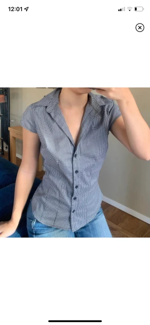 Rutig skjorta - En svart och vit rutig tshirt-skjorta med svarta knappar. Snygg v-ringning. 💋 gratis frakt idag + imorgon, 29-30 jan