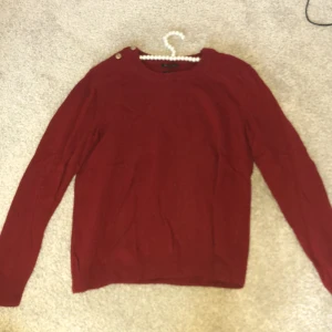 Vinröd tröja - Säljer denna super fina vinröda överträdande med fina dekorationer på axlarna. Är i bra skick och priset går att diskutera. 