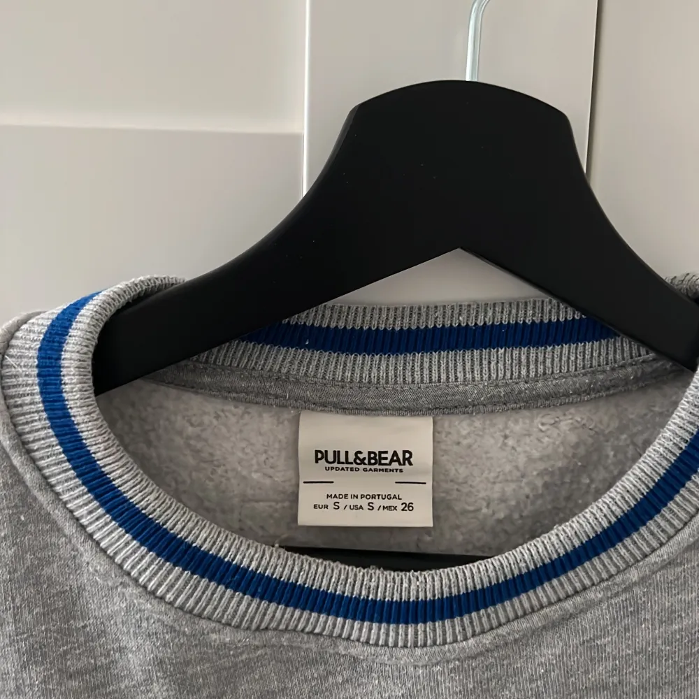 En grå sweatshirt med blått tryck från PULL&BEAR❤️är i bra skick.. Tröjor & Koftor.