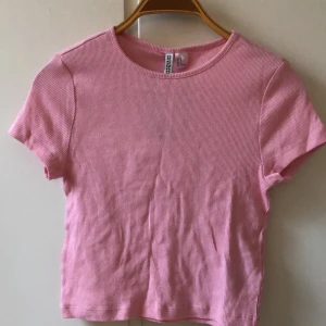 Rosa croptopo - Oanvänd rosa ribbad croptop från hm. Den passar perfekt nu till sommarn och den är helt oandvänd och därför inga defekter eller skador, skriv om ni har några frågar så svarar jag så snabbt jag kan!!💘