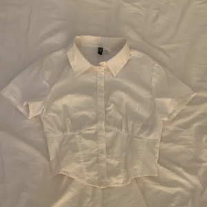 Vit topp från hm - Vit topp från hm🤍 köpte den till skolavslutningen men använde den aldrig så den är bara testad. Har som en liten korsett längst ner och knappar. 35kr + frakt köpte för 99kr