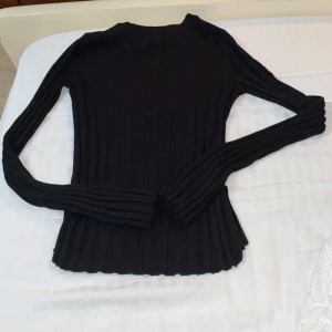 Svart tröja - En jättefin svart tröja som är ribbad. Har snittar vid sidorna (se bild). Har lite utsvängda armar. Är i storlek XS. Köparen står för frakten ❤️