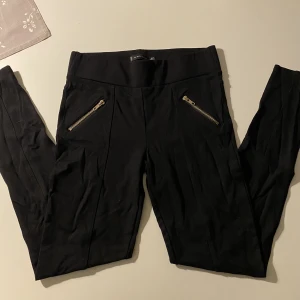 Svarta tights (strl. 40) - Ett par svarta tights köpta från NewYorker i storlek 40. Nypris ca 250kr. Superbra skick och är materialet är väldigt lent. Kedjor på sidorna som dekor (inte förvaringsutrymmen). Priset kan alltid diskuteras!