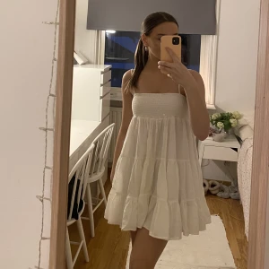 Vit Zara-klänning  - Säljer min vita klänning från Zara då den aldrig har kommit till användning. Nypris 400kr Köpt denna sommar, därav nyskick. Den är smockad upptil med tunna band och avslappnad nedtill- jättefin! Klänningen är i strlk S🤍 Köparen står för frakt!