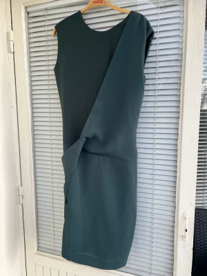 Filippa K klänning  - Superfin mörkgrön klänning från Filippa K säljes, kan bäras åt båda hållen. Strl: S. Lite nopprig men syns enbart på nära håll.   Spårbar frakt: 66kr. 