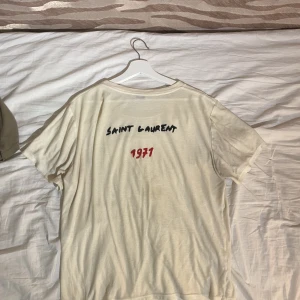 Ysl Logo T-Shirt - Saint Laurent T-shirt med Logga på ryggen. Bra skick men använd. Nypris:3600kr Mer info och bilder i dm