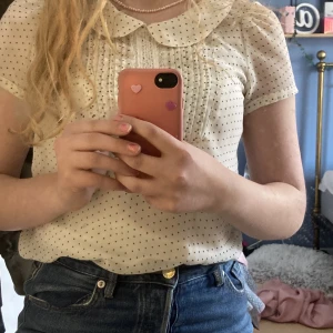 Blus - Söt prickig blus med volanger.