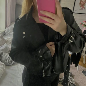 Bikerjacket (skinnjacka) - Svart kort skinnjacka från Nelly med tillhörande bälte, storlek 38. Nyskick🤩 Priset kan diskuteras😄