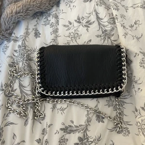 Tiamo väska med kedja - Svart Tiamo väska med kedja! Nästan helt oanvänd och är i toppen skick! Ett större fack och ett litet inuti🤍🤍 