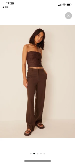 Bruna kostymbyxor NA-KD  - ”Relaxed suit trousers” från NA-KD i storlek 36. Oanvända med prislappen kvar. Modellen är 173cm lång och när också strl 36. Byxorna kostar 500kr på sidan💕