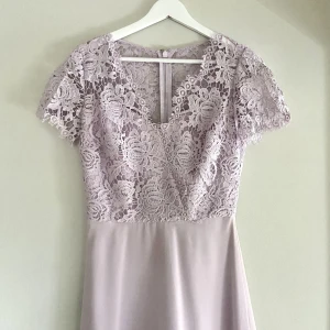 Balklänning - En syrenlila maxiklänning köpt från Nelly med dekorativ spets. Endast använd en gång. Passar perfekt som balklänning eller till bröllop!   Storlek: Uk 6/34 Material: 100% polyester Skick: fint skick, använd 1 gång