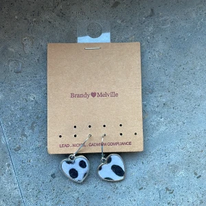 Örhängen  - Ett par gulliga hjärt örhängen med ko print på i nyskick. Säljer pga att de inte används. Köptes för 120kr från brandy Melville. Köparen står för frakt på 15kr eller mötas upp. Pris kan diskuteras💞