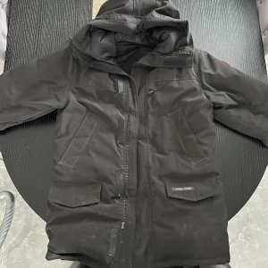 Canada goose - En fin Canada goose lång modell, storlek L och då ni ser att den är skitig på första bilden så ska den kemtvättas innan den säljs.  Använd två vintrar och är i nyskick