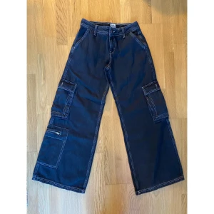 Puddle cargo jeans UO strl 27/32 - Skitsnygga lågmidjade cargojeans från urban outfitters i modellen puddle. Nyskick! Säljes pga för små för mig, obs små i storleken!! Passar mer som 26/32. Skriv vid frågor<3 