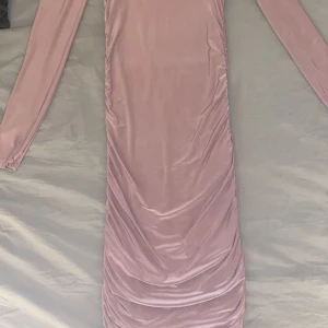 Fin klänning  - En fin rosa klänning med bara axlar och långärmad. Den är i str S men sitter tajt på mig som är en XS. Den har lite ”scrunchade” detaljer på sidorna så den sitter jätte fint på! Den är även i fint skick. Den går lite över knäna på mig som är 1,72 cm.  