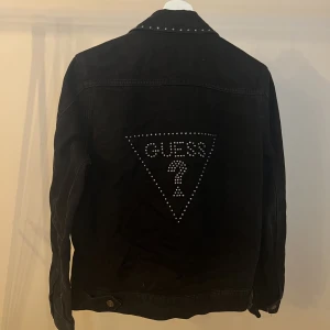 Jeansjacka från Guess - Vääärldens snyggaste jeansjacka från Guess i storlek S. Skitcool med stenar runt kragen och på ryggen. Fint använt skick!