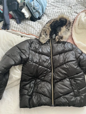 Lindex jacka - Jacka från Lindex svart med päls på luvan jag har använt den men nu är den för liten!