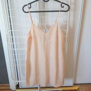 Beige/rosa klänning från NA-KD. Aldrig använd och prislappen sitter kvar. Nyskick.