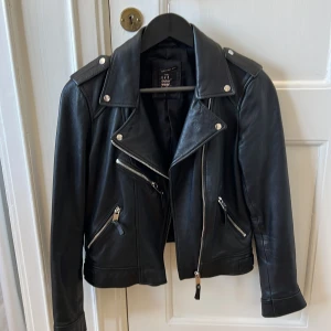 Skinnjacka bikermodell  - En schysst bikerjacka i äkta läder, mjuk och otroligt skön. Använd men inga slitage på den! Perfekta vårjackan