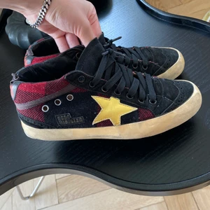 Golden Goose sneakers - Svarta/ röda sneakers från Golden Goose. Modellen Mid. Gul/gullig stjärna. 