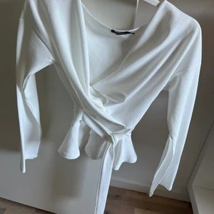 Blus  - Fin vit blus köpt från Boohoo men fina slits på armarna. Passar perfekt till vardag men även till en fest outfit. I skick som ny och i storlek 34   Köparen står för frakt 