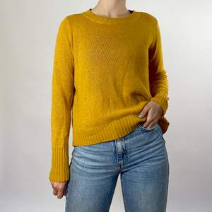 En gul stickad tröja som inte använts på länge. Den är ganska tunn och lätt men väldigt skön