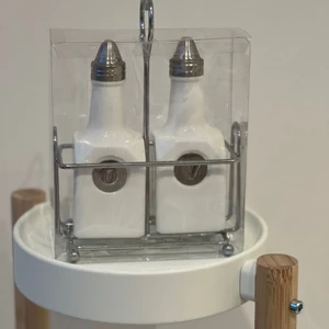 Olja-vinäger ställ - Olja-vinäger ställ i förpackning. Helt ny:) Båda flaskorna i porslin+ ett ställ runtomkring med ett hjärtformat handtag!   Betalning sker endast via Swish. Paketet skickas i posten. Kund står för frakten. 