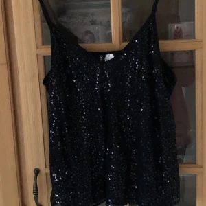 Top - En snygg svart Top med paljetter. Cirka 2 år gammal.