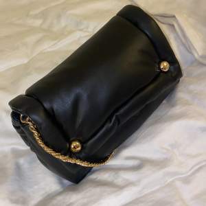 svart piffig väska med gulddetaljer samt guldknappar! använd max 2 gånger. i jättebra skick. 