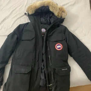 Canada goose Expedition Parka - Detta är en väldigt fräsch jacka som verkligen värmer en. Pälsen är väldigt fin och jackan har 9 fickor (finns även bröstfickor för att värma händerna). Jag har haft jackan i 5 år och inte stött på ett enda problem alls. Väldigt fin jacka i överlag.