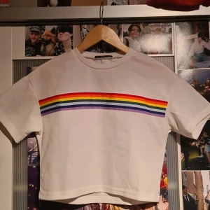 Vit T-shirt med Regnbåge - En croppad tröja från shein som jag köpte på second hand. Använde aldrig tröjan efter köp.