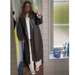 Brun läderkappa  - Storlek S, som ny!  Verkligen supersnygg!!!😍 Köpt för 1300 kr för ett halvår sen! Är även skärp runt som man kan knyta den med