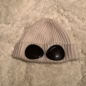 Cp Company mössa - Den här mössan är i jätte bra skick och den är lätt 7,8/10 i skicket! Original pris är 1200kr. Vet ej vilken strl det är på den men den är lite förstor på mig och jag har ett jätte litet huvud!