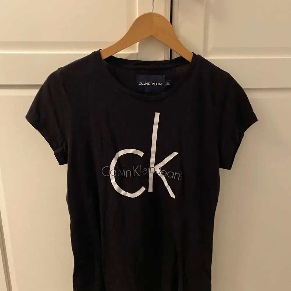 Svart Calvin Klein t-shirt med vitt tryck. T-shirts.
