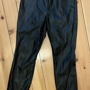 Svarta "skinnbyxor, "läderbyxor" i fejkmaterial - Snygga "skinnbyxor" i hög kvalitet och inte så blanka som billigare ofta är. Inlöpta på Sthlm Blvd och använda 4 ggr. 