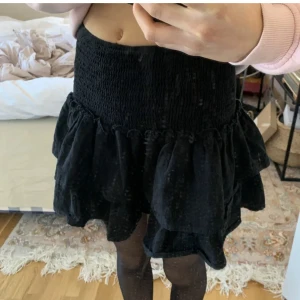 Svart Volangkjol från Shein - ‼️första bilden är lånad🫶 Säljer denna volangkjolen som även går att använda som en topp! Den är i bra skick förutom att den har en liten fläck på (jag kan skicka bild) annars bra skick och passar perfekt nu till vintern med ett par strumpbyxor👌🏻👌🏻