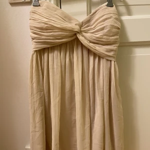 Härlig klänning - Champagnefärgad jättefin klänning utan axelband. Sparsamt använd ✨