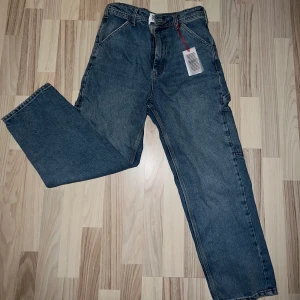Blåa byxor från Urban Outfitters/BDG - Säljer dessa skitsnygga byxor med coola detaljer pga att dom inte sitter bra på mig. Dom är lite för korta men sitter bra runt midja. Tål att tilläggas, byxorna är ifrån ”herrsidan” därav passform och modell.  Storlek: W28 L30 Jag är 163😊 