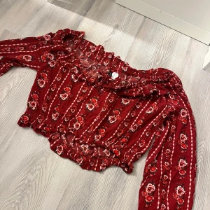 Blommig blus - Den här röda blusen är ifrån HM i storlek 38, säljer denna för 50kr!