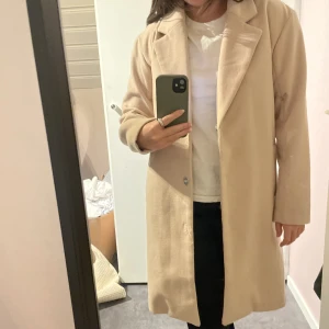 Beige kappa  - Beige kappa köpt på Nelly (Nypris 799kr). Fint skick förutom att översta knappen gått sönder (se sista bilden, lätt att du fast) 